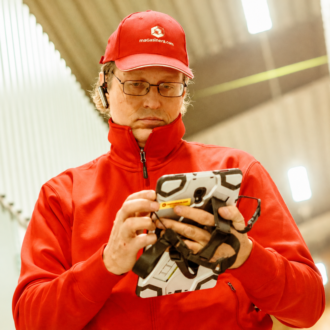 Magasineras fastighetsskötare använder en mobiltelefon